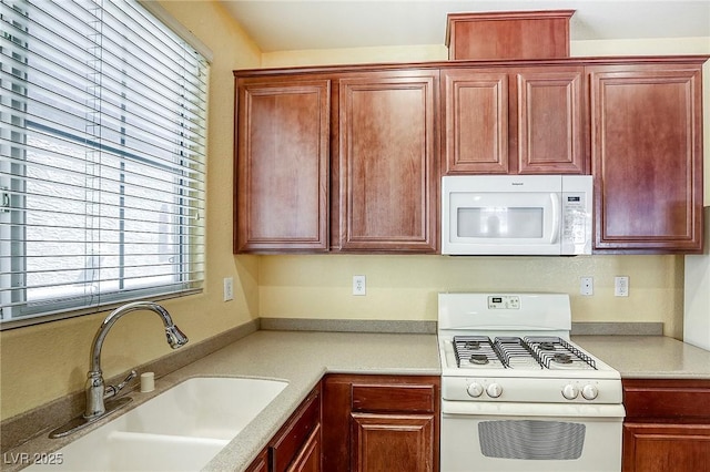 3905 Sweet Pine St Unit 102, Las Vegas, NV 89108 - kitchen with white appliances, light countertops, and dark brown cabinets