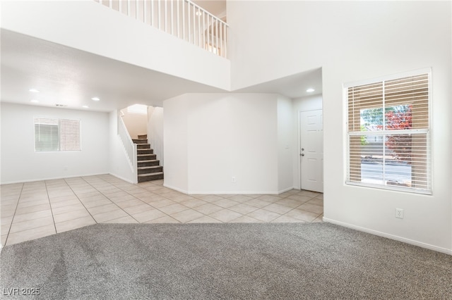 7553 Virginia Dale St, Las Vegas, NV 89131 - unfurnished living room featuring carpet flooring, stairs, tile patterned flooring, a towering ceiling, and recessed lighting