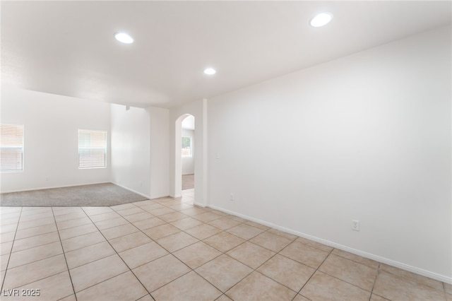 7553 Virginia Dale St, Las Vegas, NV 89131 - spare room featuring arched walkways, recessed lighting, light tile patterned flooring, and light carpet