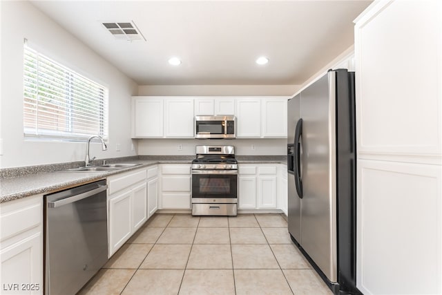 7553 Virginia Dale St, Las Vegas, NV 89131 - kitchen with appliances with stainless steel finishes, light tile patterned flooring, white cabinets, and recessed lighting