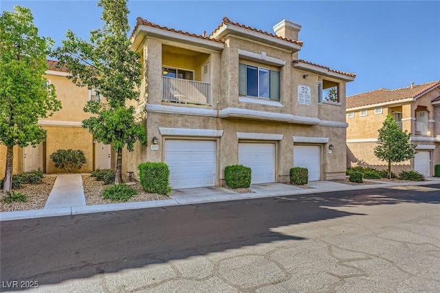 251 S Green Valley Pkwy Unit 3222, Henderson, NV 89012 - townhome / multi-family property featuring stucco siding, a tiled roof, a chimney, a garage, and a balcony