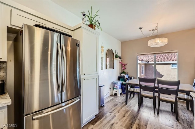 251 S Green Valley Pkwy Unit 3222, Henderson, NV 89012 - kitchen featuring freestanding refrigerator, wood finished floors, white cabinets, decorative light fixtures, and a chandelier