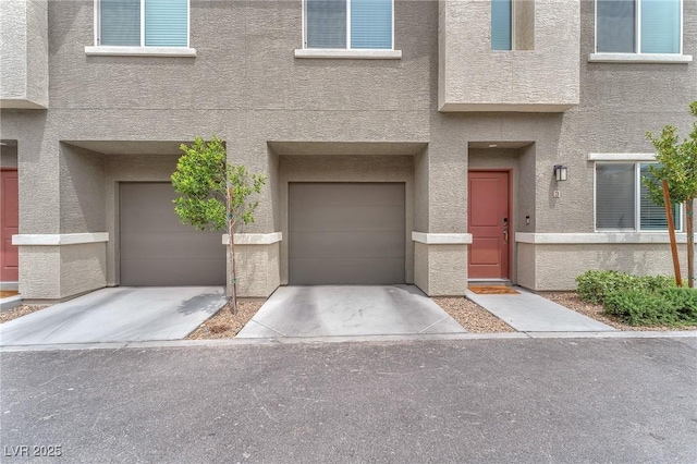 12280 Golden Wreath Rd Unit 3, Las Vegas, NV 89183 - view of front of house featuring a garage, stucco siding, and driveway
