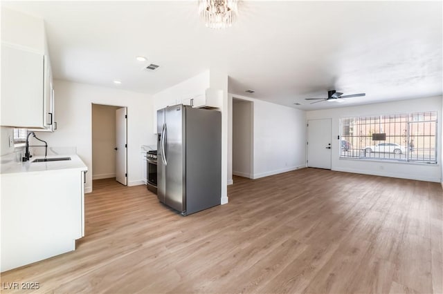 1648 J St, Las Vegas, NV 89106 - kitchen with appliances with stainless steel finishes, white cabinets, light wood-type flooring, ceiling fan, and light countertops