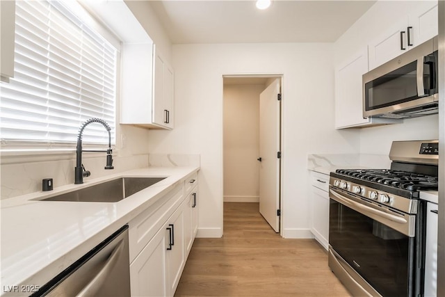 1648 J St, Las Vegas, NV 89106 - kitchen featuring appliances with stainless steel finishes, light wood-type flooring, white cabinets, and recessed lighting