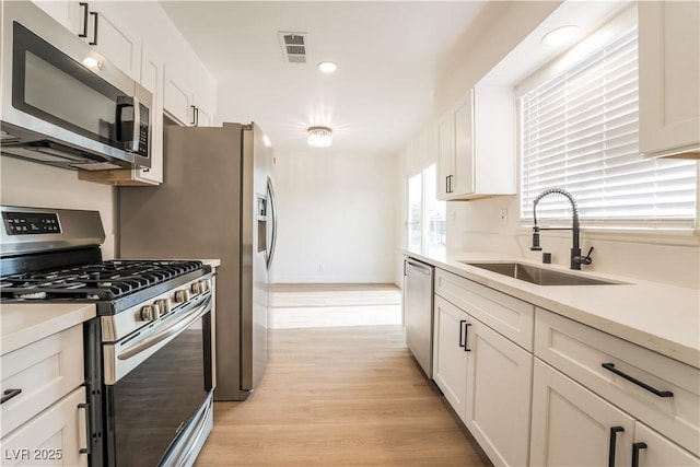 1648 J St, Las Vegas, NV 89106 - kitchen featuring appliances with stainless steel finishes, light wood-style flooring, white cabinets, light countertops, and recessed lighting