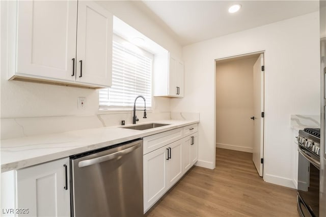 1648 J St, Las Vegas, NV 89106 - kitchen featuring stainless steel appliances, white cabinets, light wood-style floors, light stone countertops, and recessed lighting