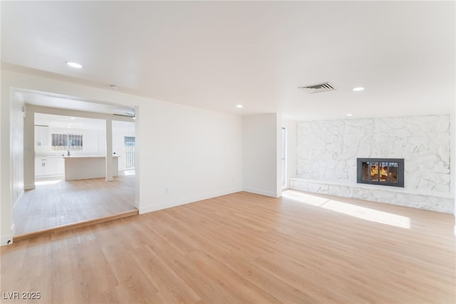 3320 Osage Ave, Las Vegas, NV 89101 - unfurnished living room with light wood-type flooring, a fireplace, and recessed lighting