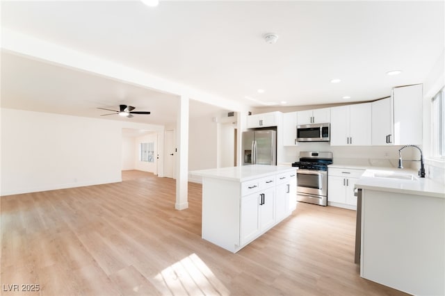 3320 Osage Ave, Las Vegas, NV 89101 - kitchen featuring appliances with stainless steel finishes, a center island, light countertops, light wood-type flooring, and recessed lighting