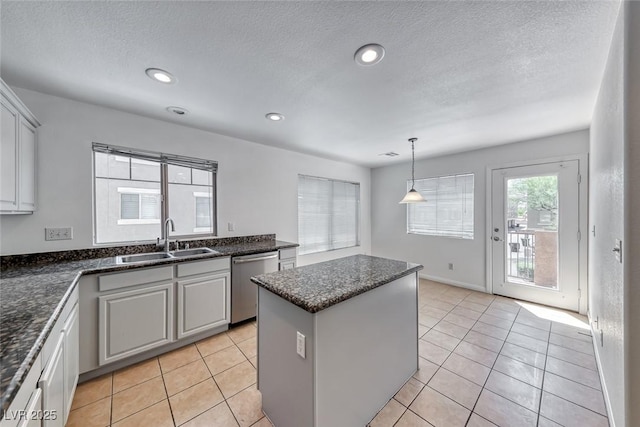 2766 Red Vista Ct, Henderson, NV 89074 - kitchen featuring stainless steel dishwasher, a center island, a textured ceiling, recessed lighting, and light tile patterned floors