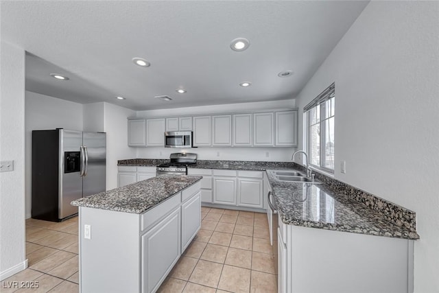 2766 Red Vista Ct, Henderson, NV 89074 - kitchen with appliances with stainless steel finishes, a center island, light tile patterned floors, dark stone countertops, and recessed lighting