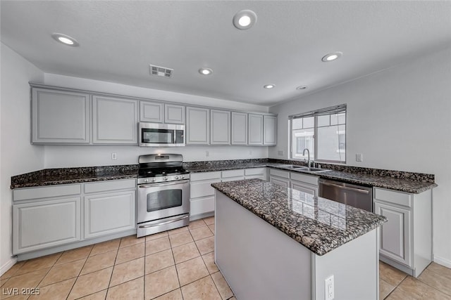 2766 Red Vista Ct, Henderson, NV 89074 - kitchen with appliances with stainless steel finishes, dark stone counters, a center island, recessed lighting, and light tile patterned flooring