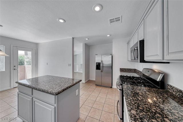 2766 Red Vista Ct, Henderson, NV 89074 - kitchen with appliances with stainless steel finishes, a kitchen island, light tile patterned flooring, recessed lighting, and dark stone counters