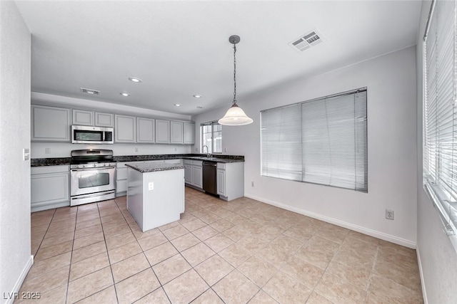 2766 Red Vista Ct, Henderson, NV 89074 - kitchen with stainless steel appliances, gray cabinets, a kitchen island, recessed lighting, and light tile patterned flooring