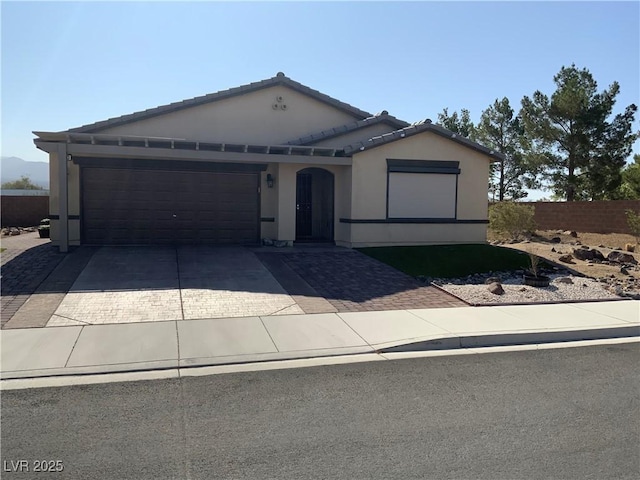 5363 S Juneau St, Pahrump, NV 89061 - view of front of home featuring driveway, a garage, stucco siding, and a tile roof