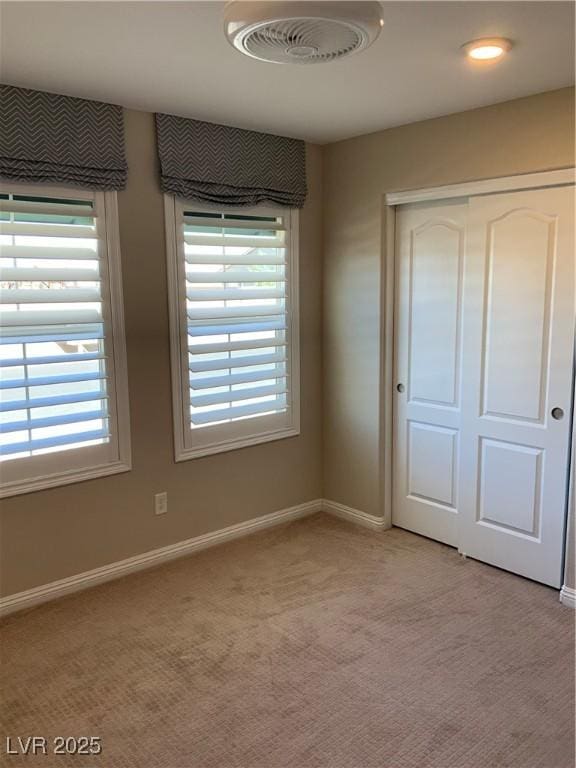5363 S Juneau St, Pahrump, NV 89061 - unfurnished bedroom featuring multiple windows, light carpet, and a closet