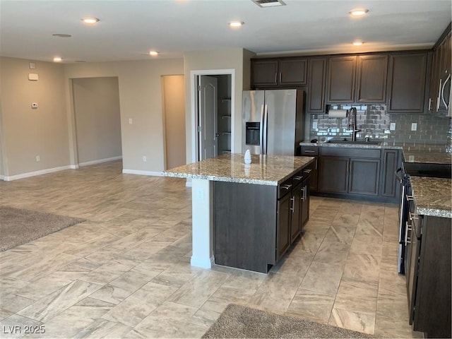 5363 S Juneau St, Pahrump, NV 89061 - kitchen with appliances with stainless steel finishes, a kitchen island, decorative backsplash, stone countertops, and recessed lighting