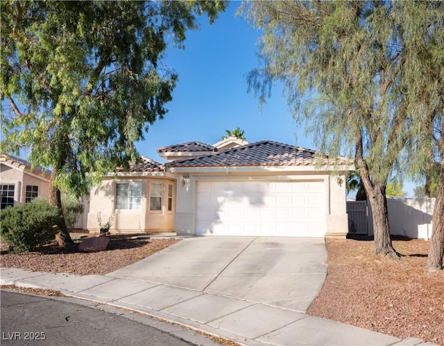 4848 Cutting Diamond Ct, North Las Vegas, NV 89081 - mediterranean / spanish-style home with concrete driveway, a tile roof, stucco siding, and an attached garage