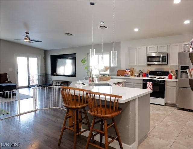4848 Cutting Diamond Ct, North Las Vegas, NV 89081 - kitchen featuring stainless steel appliances, light countertops, a ceiling fan, a breakfast bar area, and recessed lighting