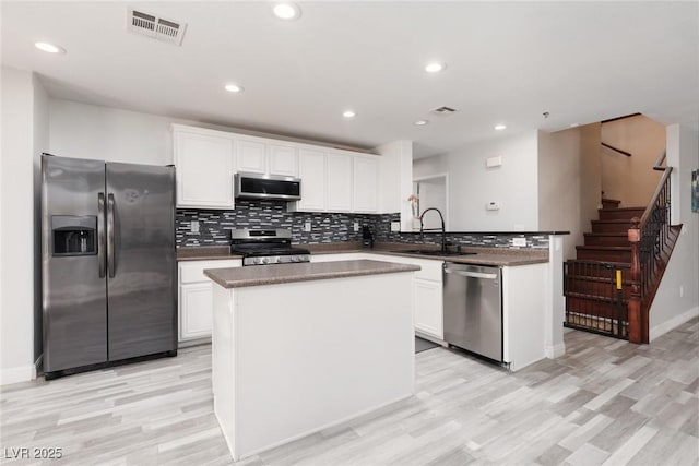 5620 Siena Rose St, North Las Vegas, NV 89031 - kitchen with appliances with stainless steel finishes, light wood finished floors, a peninsula, white cabinets, and recessed lighting