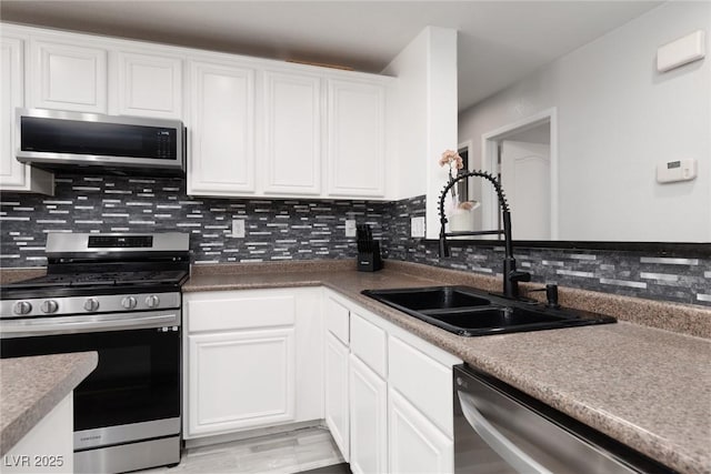 5620 Siena Rose St, North Las Vegas, NV 89031 - kitchen with appliances with stainless steel finishes, backsplash, white cabinets, and light wood-type flooring