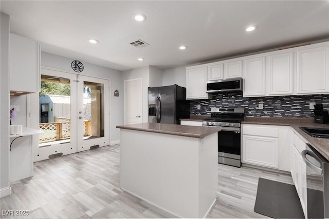 5620 Siena Rose St, North Las Vegas, NV 89031 - kitchen with appliances with stainless steel finishes, a kitchen island, white cabinetry, backsplash, and recessed lighting