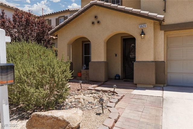 5620 Siena Rose St, North Las Vegas, NV 89031 - property entrance featuring stucco siding, a tile roof, and a garage
