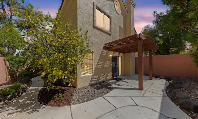 9409 Kayla Ct, Las Vegas, NV 89134 - property exterior at dusk featuring a patio, stucco siding, and a pergola