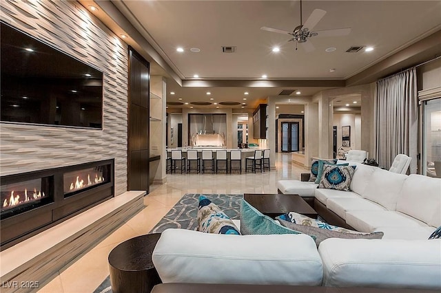 15 Golden Sunray Ln, Las Vegas, NV 89135 - living room featuring a ceiling fan, a tile fireplace, recessed lighting, a raised ceiling, and light tile patterned floors