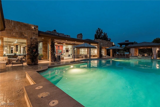 15 Golden Sunray Ln, Las Vegas, NV 89135 - pool at night featuring a gazebo, an outdoor pool, a patio area, and an outdoor living space