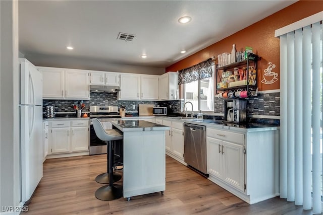 1048 Menands Ave, Las Vegas, NV 89123 - kitchen with appliances with stainless steel finishes, under cabinet range hood, backsplash, white cabinets, and recessed lighting