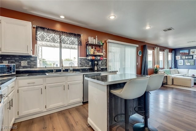1048 Menands Ave, Las Vegas, NV 89123 - kitchen with stainless steel appliances, wood finished floors, plenty of natural light, a kitchen bar, and recessed lighting