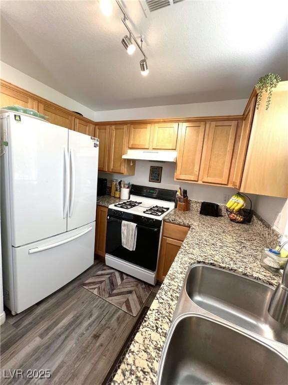 39 Belle La Blanc Ave, Las Vegas, NV 89123 - kitchen with freestanding refrigerator, gas range oven, under cabinet range hood, rail lighting, and wood finished floors