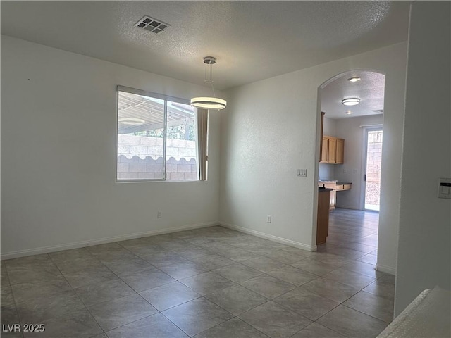 8042 Palace Monaco Ave, Las Vegas, NV 89117 - unfurnished dining area with arched walkways, a textured ceiling, and tile patterned floors