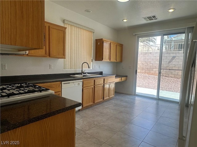 8042 Palace Monaco Ave, Las Vegas, NV 89117 - kitchen featuring dishwasher, dark countertops, range, brown cabinets, and a textured ceiling