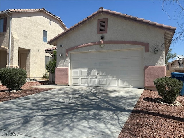 8042 Palace Monaco Ave, Las Vegas, NV 89117 - view of front facade with stucco siding, an attached garage, driveway, and a tiled roof