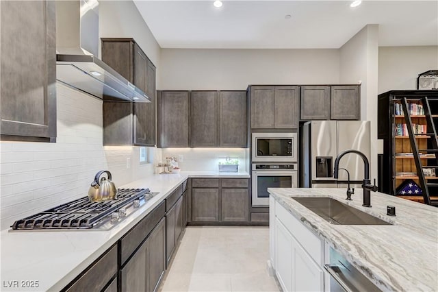 659 Spotted Falcon St, Las Vegas, NV 89138 - kitchen with appliances with stainless steel finishes, wall chimney exhaust hood, dark brown cabinets, light stone counters, and recessed lighting