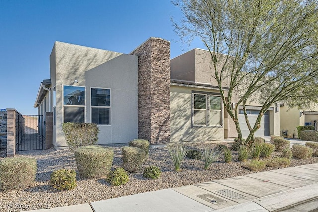 6834 Compass St, North Las Vegas, NV 89084 - view of front of property featuring a gate, stucco siding, and a chimney