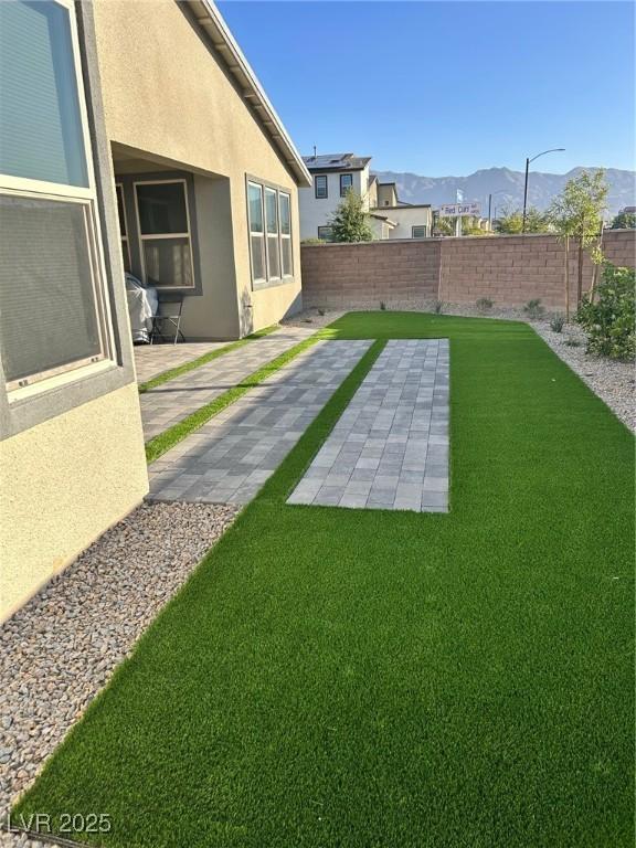 6834 Compass St, North Las Vegas, NV 89084 - fenced backyard featuring a mountain view and a patio area