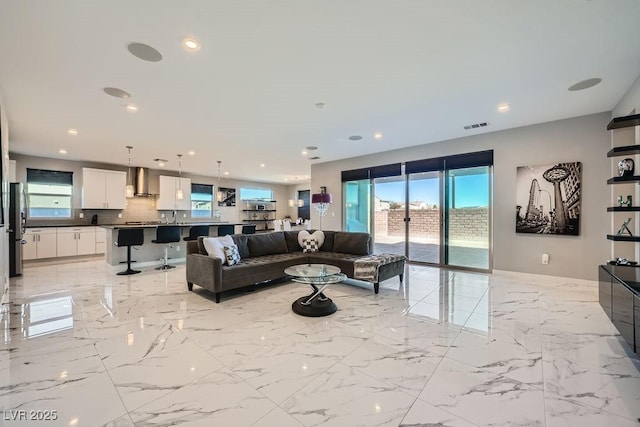 6834 Compass St, North Las Vegas, NV 89084 - living room featuring healthy amount of natural light, recessed lighting, and light marble finish flooring