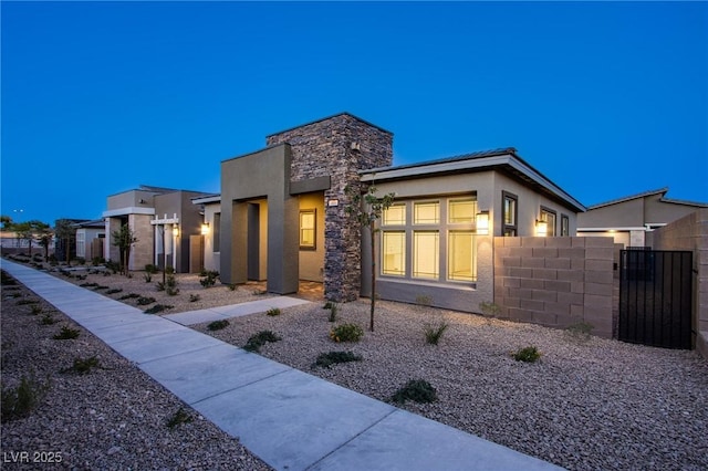 909 Allister Fields Ln, Las Vegas, NV 89138 - contemporary house featuring stucco siding, a gate, and stone siding