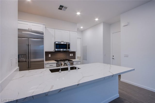 909 Allister Fields Ln, Las Vegas, NV 89138 - kitchen with stainless steel appliances, light stone countertops, backsplash, white cabinets, and recessed lighting