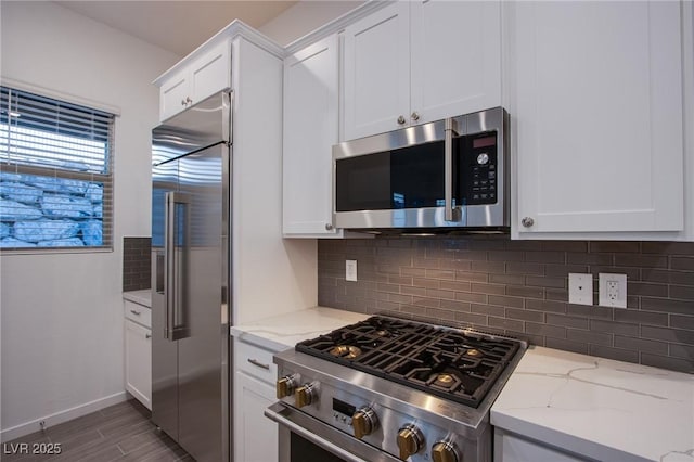 909 Allister Fields Ln, Las Vegas, NV 89138 - kitchen featuring high quality appliances, decorative backsplash, light stone countertops, and white cabinets