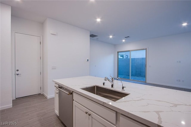 909 Allister Fields Ln, Las Vegas, NV 89138 - kitchen with light stone counters, white cabinets, light wood finished floors, stainless steel dishwasher, and recessed lighting