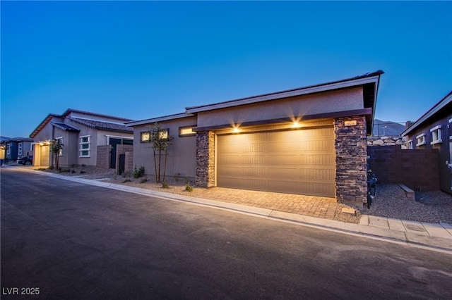 909 Allister Fields Ln, Las Vegas, NV 89138 - view of front of home with stone siding, stucco siding, a garage, and driveway