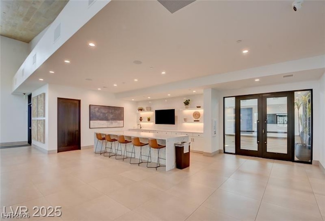 909 Allister Fields Ln, Las Vegas, NV 89138 - kitchen with white cabinetry, french doors, a breakfast bar area, light countertops, and open shelves