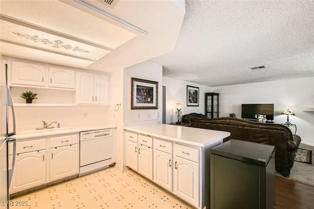 1104 Pinto Rock Ln Unit 101, Las Vegas, NV 89128 - kitchen featuring dishwasher, a peninsula, a textured ceiling, open floor plan, and light countertops