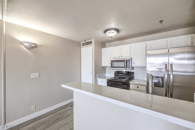 1381 E University Ave Unit 204, Las Vegas, NV 89119 - kitchen featuring appliances with stainless steel finishes, light wood finished floors, white cabinets, and light stone counters