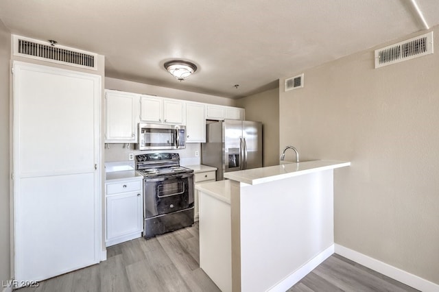 1381 E University Ave Unit 204, Las Vegas, NV 89119 - kitchen with appliances with stainless steel finishes, light wood-type flooring, a peninsula, white cabinets, and light countertops