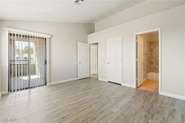 5038 S Rainbow Blvd Unit 206, Las Vegas, NV 89118 - unfurnished bedroom with lofted ceiling, light wood-style floors, access to exterior, and connected bathroom
